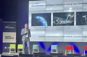 Max Najork on Stage at the New Space Summit in front of a presentation.